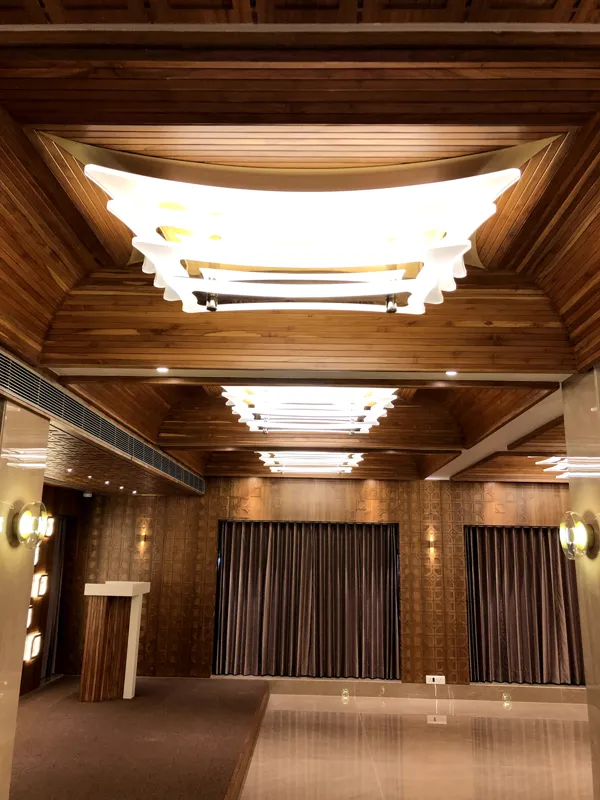 Chandelier and wooden ceiling detail in the Ashirwad hall