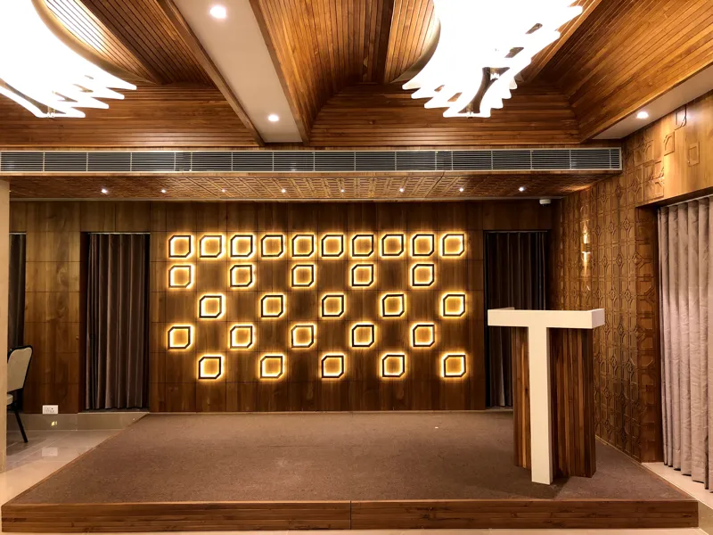 Banquet stage with illuminated feature wall and wooden ceiling at Ashirwad
