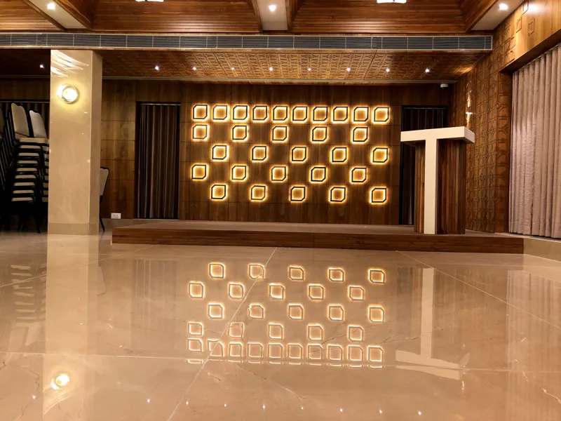 Polished marble floor and lit feature wall in the Ashirwad banquet hall