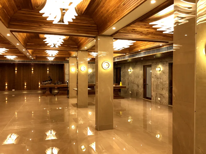 Pillared hall with warm wood panelling and chandeliers